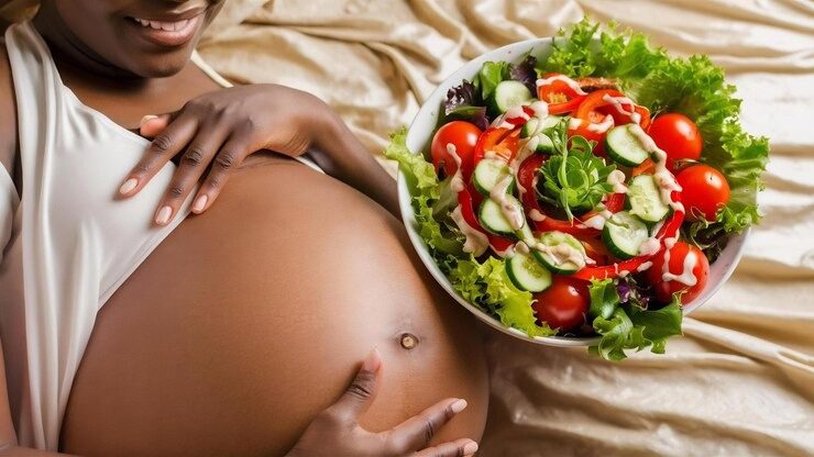 Pregnant woman with a bowl of vegetable salad